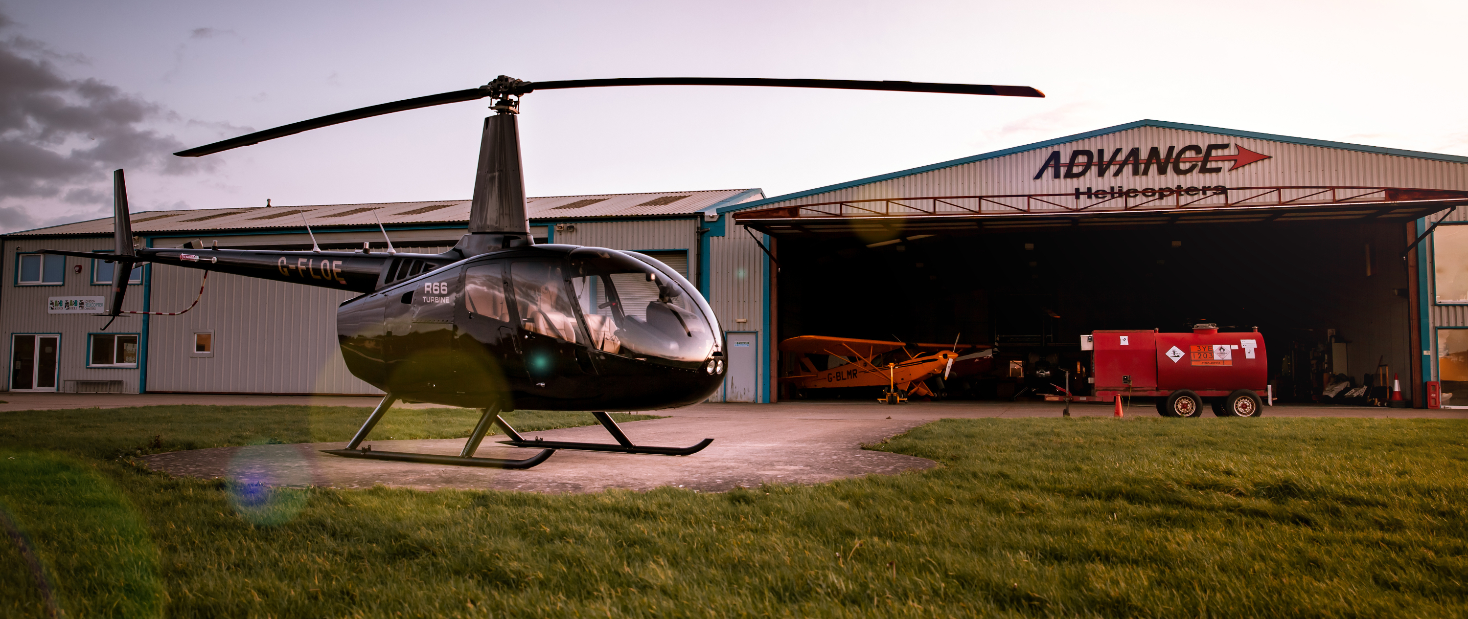 Robinson R66 turbine helicopter in front of Advance Helicopters hangar